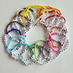 a bunch of bracelets that are all different colors and sizes on a white surface