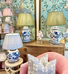 blue and white vases sitting on top of a table next to lamps