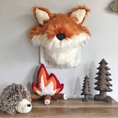 a stuffed animal is sitting on a shelf next to a wall mounted fox and hedgehog