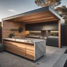 an outdoor kitchen that is built into the side of a fenced in backyard area