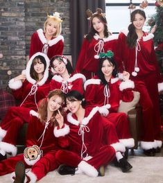 a group of women dressed in red and white christmas outfits posing for a photo together