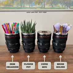 three coffee mugs filled with pens, pencils and other office supplies on top of a wooden table