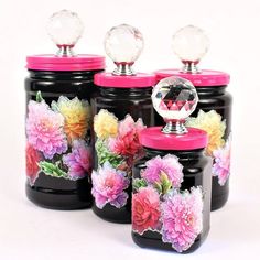 four black jars with colorful flowers painted on them