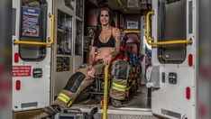 a woman sitting in the back of a firetruck with her legs crossed and wearing safety gear