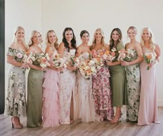 a group of women standing next to each other holding bouquets