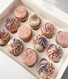 twelve cupcakes in a white box with pink frosting