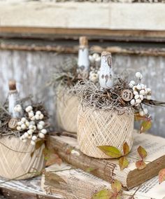 three wicker pumpkins decorated with flowers and candles on top of an old book