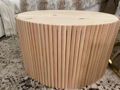 a round wooden table sitting on top of a rug