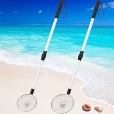 two beach rakes sitting on top of a sandy beach next to the ocean with seashells