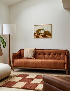 a living room filled with furniture and a painting on the wall above it's couch