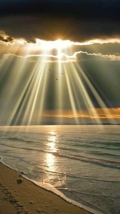 the sun shines brightly over the ocean as it reflects in the water on a beach