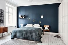 a bedroom with blue walls and white floors