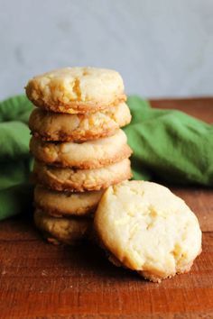 a stack of cookies sitting on top of a wooden table next to a green cloth