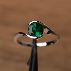 It is a lab emerald ring. The main stone is 7mm*7mm round cut, weight about 1.3 carats. The basic metal is sterling silver and plated with rhodium. To change the metal to a solid gold (white/rose) or platinum is also available, please ask for a quotation if you want. You can also go to my shop Home for more elegant rings:  https://www.etsy.com/shop/godjewelry?ref=hdr_shop_menu More rings: https://www.etsy.com/shop/godjewelry?ref=l2-shop-header-avatar Customization is always welcome and please fe Slytherin Jewelry, Emerald Solitaire Engagement Ring, Engagement Ring Round Cut, Elegant Rings, Green Gemstone Ring, Engagement Ring Round, Emerald Rings, Round Cut Engagement Rings, Engagement Rings Round