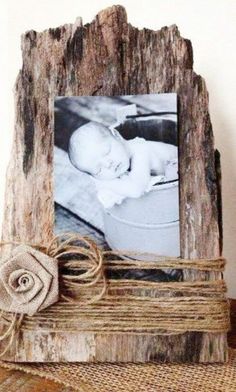 an old wooden frame with a baby's photo on it and twine around the edges