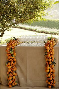 oranges are arranged in the shape of an arch on top of a white table cloth