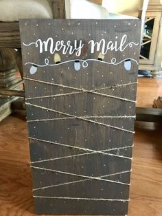 a wooden sign with string wrapped around it that says merry mail on the front and side