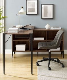 a desk with a chair, lamp and pictures on the wall