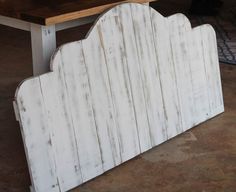 a white wooden bench sitting on top of a floor