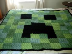 a bed with a green and black blanket on top of it