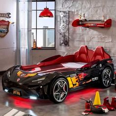 a black sports car with red and yellow stripes on it's side in a garage