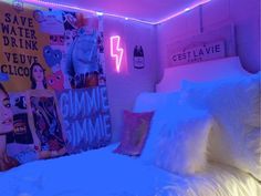 there is a bed with white sheets and pillows in the room that has neon lights on it