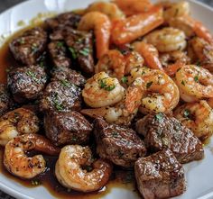 a white plate topped with meat and shrimp