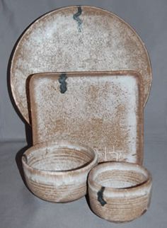 a set of dishes and cups are sitting on a table top, with one bowl in the middle