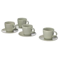 four white cups and saucers sitting on top of each other