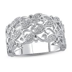 a white gold ring with diamonds in the center and an intricate design on the side