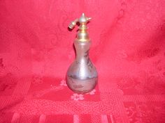 a silver vase sitting on top of a red cloth