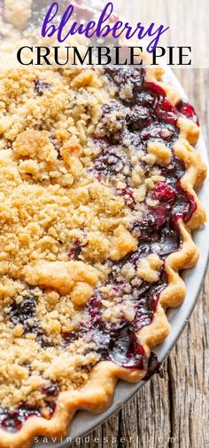 a blueberry crumble pie sitting on top of a wooden table