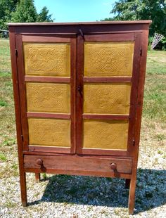 an old wooden cabinet sitting in the grass