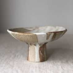 a white and brown bowl sitting on top of a table