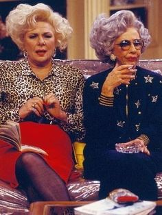 two women sitting on a couch talking to each other