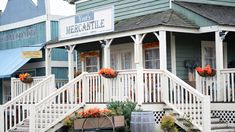 an old fashioned building with flowers on the porch