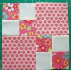 the block is made up of pink and white fabric, with flowers on it's sides