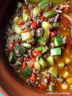 a wooden spoon in a bowl filled with soup