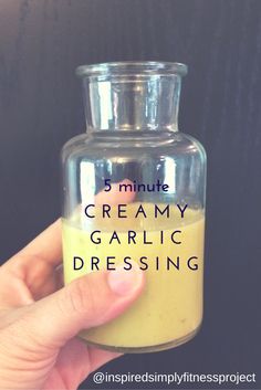 a hand holding a small jar filled with creamy garlic dressing text reads 5 minute creamy garlic dressing