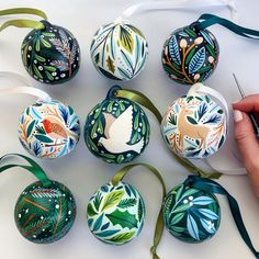 hand painted christmas ornaments are being decorated with ribbon