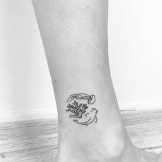 a black and white photo of a person's foot with a flower tattoo on it