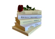 four books stacked on top of each other with a single red rose sitting atop them