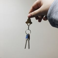 a person is holding two keys in their hand