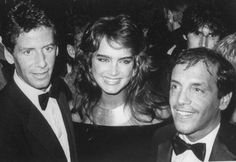 two men and a woman in tuxedos at an event