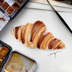 an artist's work with some food and paint on the table next to it