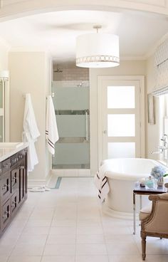 a bathroom with a tub, sink and mirror