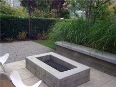 a concrete fire pit sitting in the middle of a garden