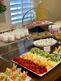 an assortment of fruits and snacks are on display in front of the buffet at this wedding reception