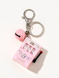 a pink keychain with an assortment of items on it and a pair of scissors