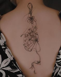 the back of a woman's neck with flowers on it